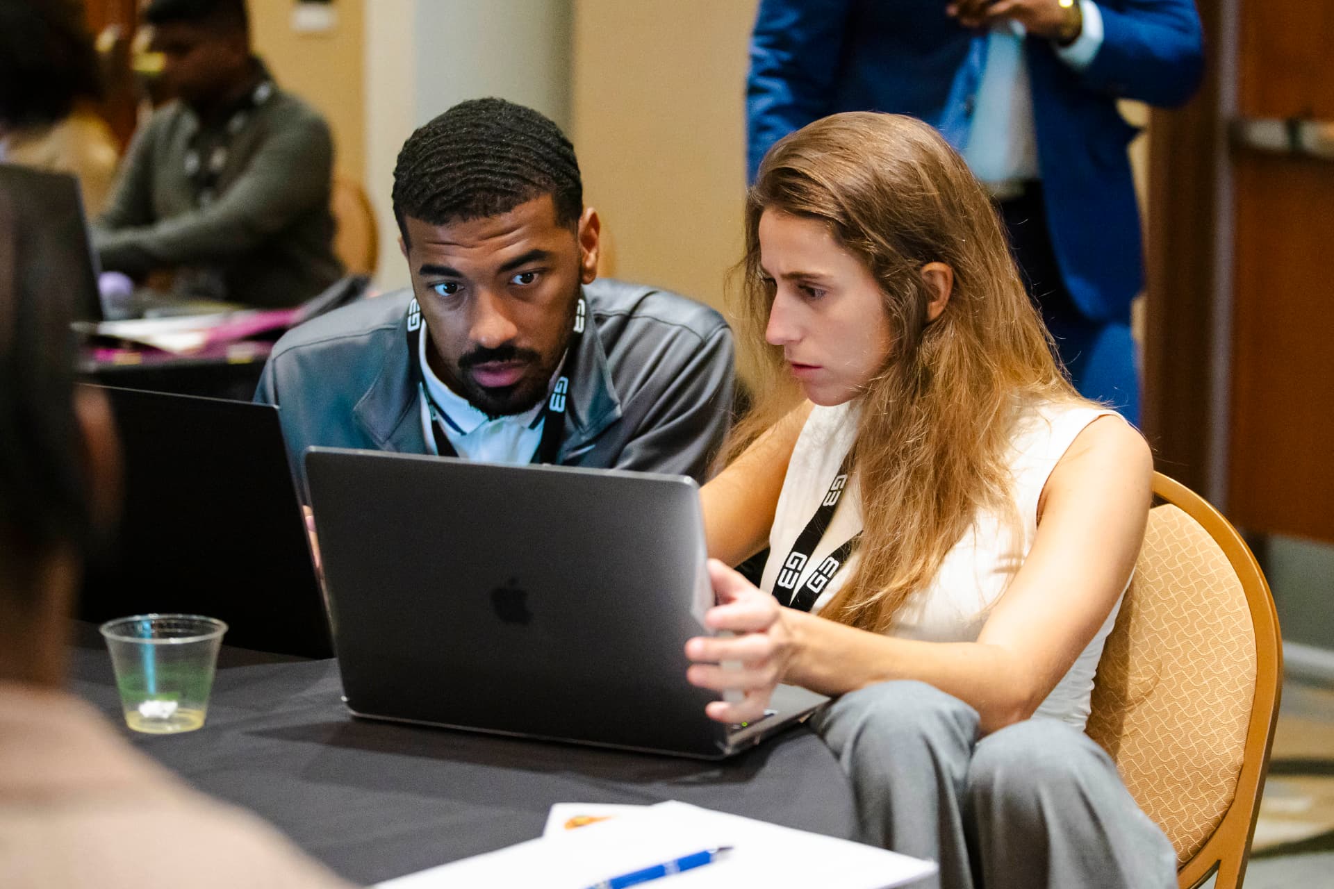 Two attendees working together on a laptop