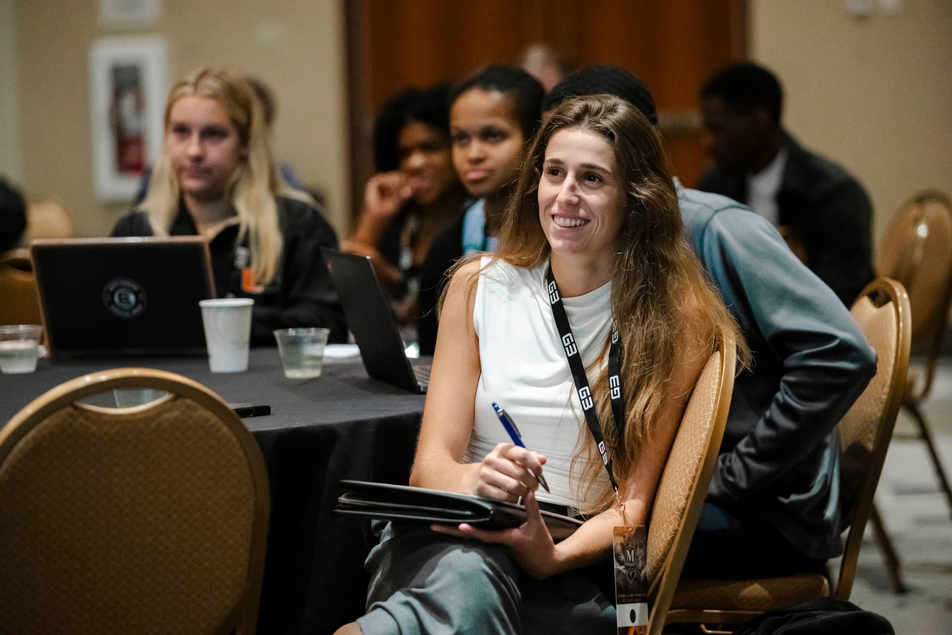 An attendee smiling and taking notes at The McLendon Experience