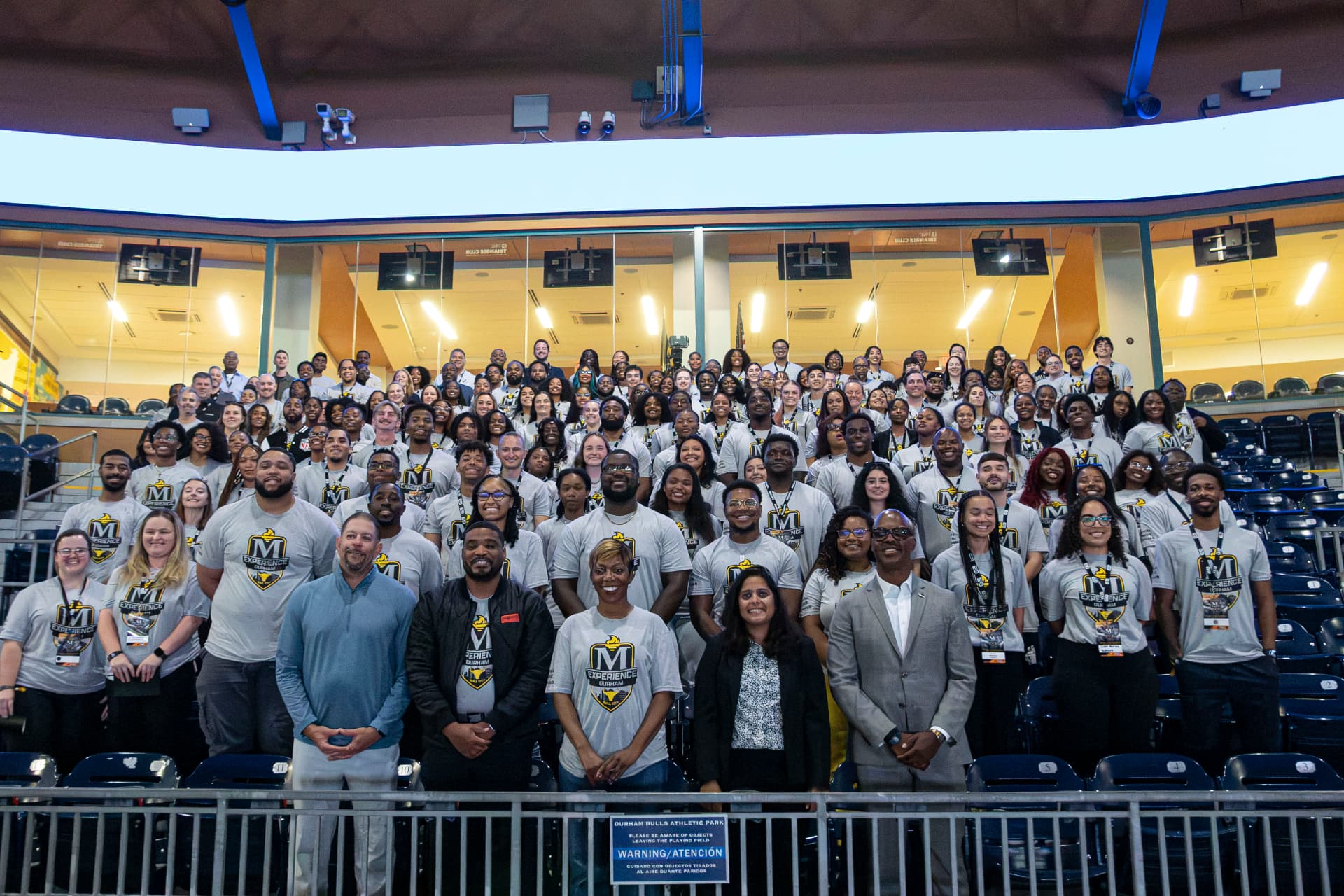 McLendon Experience participants gathered for a group photo in stadium seating at Durham Bulls Athletic Park